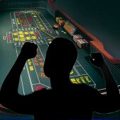 Silhouette of a man playing at a craps table