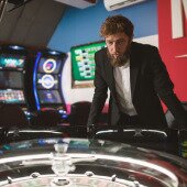 Man standing in front of roulette wheel